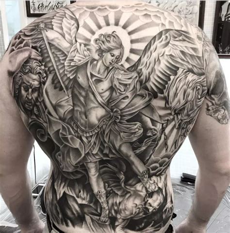 Saint Michael with Halo Tattoo. For a more serene representation, consider a tattoo of Saint Michael adorned with a halo. This design focuses on his divinity and status as a holy figure. The halo adds a sacred dimension.It often illuminates the Archangel's features and giving the entire piece a sense of peace and protection.