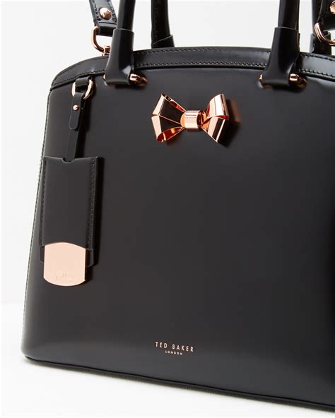 Tedbaker. Magnetic closure. Three internal pockets. Ted Baker-branded. Dimensions: H16cm x W24cm x D6.5cm. Strap drop: 55cm. Fabric & Care. Shipping & Returns. Go stylishly from day to night with Ted’s PARSON bag. Crafted from soft leather with a textured finish, it comes with a removable chain shoulder strap and handy interior pockets. 