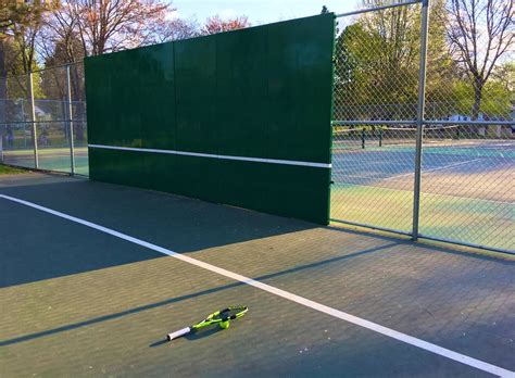 Tennis practice wall near me. How do I practice against a wall safely? Wear tennis shoes and be aware of your surroundings. Stand back far enough that any errant balls bounce well away from you. Watch the rebound carefully and avoid hitting balls straight down the wall's center for maximum safety. Call out "wall" if others are nearby. 