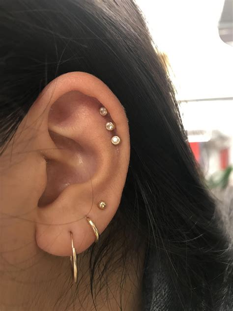 Third ear piercing. Take a bath or shower. The warm water will help soften the skin. Lubricate your ear with a non-antibiotic ointment (like Aquaphor or Vaseline) to keep the skin pliable. Gently stretch your earlobe ... 