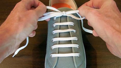 Tie shoelaces. To do this, start by threading one lace diagonally across the other lace halfway up the shoe. Then, bring the second lace under the first lace and pull it up. Next, criss-cross the laces over each other and tuck them underneath the loops on the opposite side. Finally, pull the laces tight and tie a knot. 2. 
