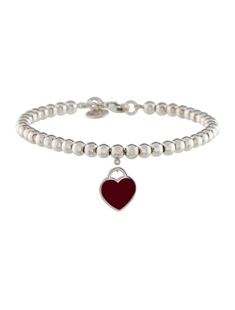 Tiffany red heart tag bead bracelet. A red heart charm adds a pop of colour to this timeless bead bracelet. Inspired by the iconic key ring first introduced in 1969, the Return to Tiffany collection is a classic reinvented. A red heart charm adds a pop of colour to this timeless bead bracelet. Sterling silver with red enamel finish. Size medium. Fits wrists up to 6.25". Beads, 4 mm. 