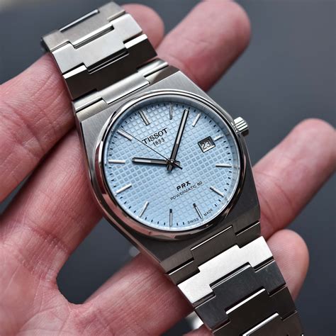 Tissot prx powermatic 80 ice blue. Transparent case back. Tonneau case shape, case size: 35 mm, case thickness: 10.9 mm. Band width: 11 mm. Butterfly clasp. Water resistant at 100 meters / 330 feet. Functions: date, hour, minute, second. Prx Series. Casual watch style. Watch label: Swiss Made. Tissot PRX Powermatic 80 Automatic Ice Blue Dial Ladies Watch T1372071135100. 