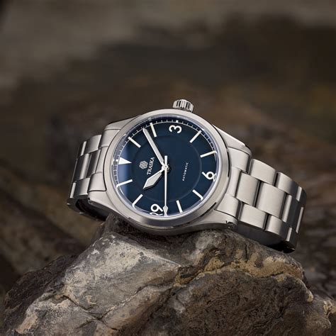 Traska. The Traska Summiteer is a 3 handed stainless steel sports watch in the same vein as the BB36, but without the eye-watering price. Could this be it? I have always liked the blue dialed 3, 6, 9 Rolex Air King watches and the Summiteer hits close to that design (with a bit of 1016 Explorer). Its size is 38.5mm so it fits almost any wrist. 