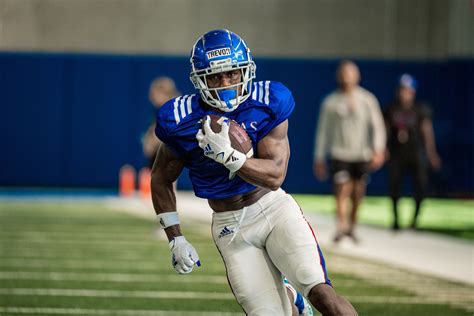 Kansas suspended starting wide receiver Trevor Wilson indefinitely and backup Tanaka Scott for the Jayhawks' season-opener on Monday after the pair were arrested last week near campus.. 