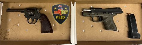 Troy residents arrested for possessing illegal guns