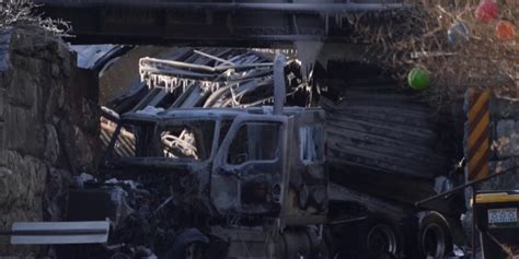 Truck carrying gas hits railroad bridge and explodes as a train passes overhead