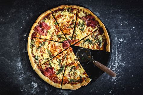 Twelve inch pizza. The diameter of a 12-inch pizza sets a standard for comparison. The area of a 12-inch pizza is approximately 113 square inches. A 12-inch pizza is typically divided into 8 slices. A 12-inch pizza can feed 2-3 people as a main fare or 4-5 people with other food options. Toppings for a 12-inch pizza can be customized to suit individual preferences. 