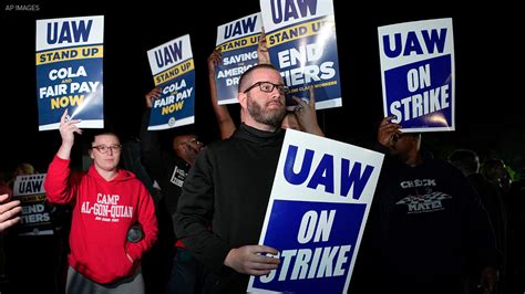 Tim Smith, center, UAW Region 8 director, stands outside with other workers as they listen to a phone call with UAW President Shawn Fain while picketing near the General Motors plant in Spring Hill, Tenn., after United Auto Workers Local 1853 announced a strike after 44 days of negotiations with GM, Sunday, Oct. 29, 2023.. 