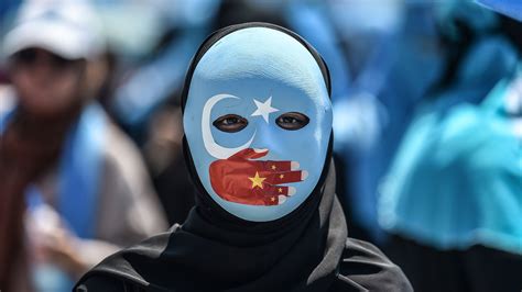 A masked demonstrator attends a protest denouncing China's treatment of Uyghur Muslims in front of the Chinese consulate in Istanbul, on July 5, 2018. Canadian senators on Tuesday voted down a .... 