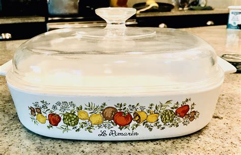 This vintage Corning Ware casserole dish is a rare find for collectors. The 1 quart dish, part of the La Marjolaine product line, features a beautiful multicolor floral design and comes with a lid for easy storage. The square shape and ceramic material make it suitable for use in electric, gas, or microwave ovens. .... 