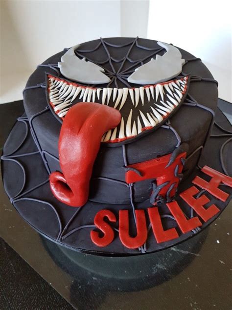 Venom cake. This Venom and Spiderman cake was a delight to make. I used the structural directions from Sugar Geek Show with the flange and plastic pipes. I cut out of wood and hand painted a sewer hole. Then I built the square cake sheets on top (double barrel style). The whole cake was covered in Ganache and then I used Chocolate … 