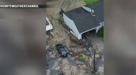 WATCH: Flooding, torrential downpours in Leominster leave vehicles dangling from driveways, car lot caving into river