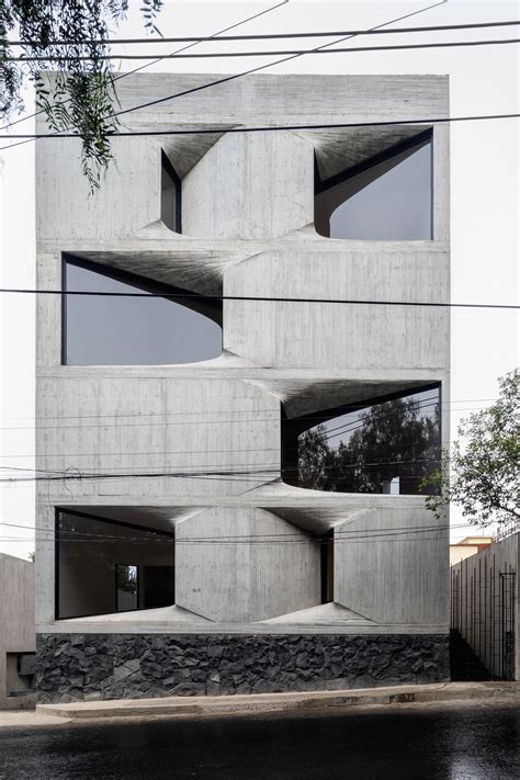 Windows punctuate board-marked concrete facade of DL1310 in Mexico City - balustradellc