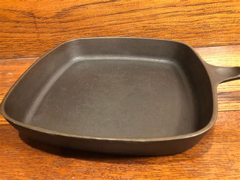 The markings on the underside of the square skillet are similar to the 1960s-era unmarked Wagner pan, as it gave the size of the pan plus a description. However, there are differences between the Wagner square skillet and BS&R, as seen below: Wagner's skillet has a lifting ridge at the top of the pan; BS&R does not. The handle shape is different.. 