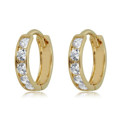  1/4 Carat Diamond Hoop Earrings are a classy and beautiful addition to your jewelry wardrobe. Each earring in this pair is accented with nine round, channel-set diamonds to spruce up any fashion wear. These gold hoop earrings are crafted in sterling silver and carry a lasting, 18kt gold plating. Add these to an outfit and you'll be sure to turn ... . 