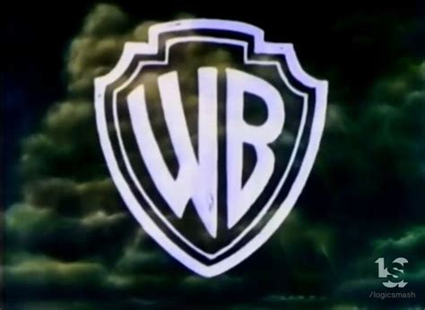 Logo: We start with the water tower of the Warner Bros. studio lot at dusk, similar to the 2021 Warner Bros. Pictures logo, but it pans from it instead of passing through. It then fades to the golden edge of the WBD shield, as it cuts through another view of it and finally through a stylized gold "100", with the WBD shield beside the "1".The text …. 