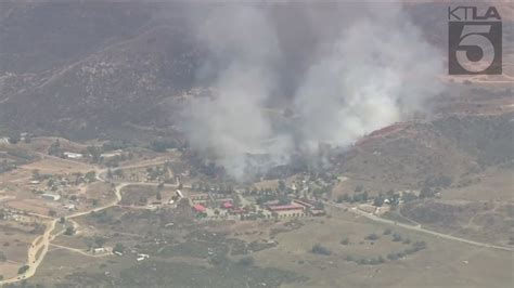 Watch live: Brush fire destroys structures in Riverside County