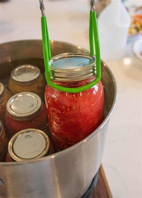 Water bath canning tomatoes. Instructions. Bring a large pot of water to a boil. Using a knife, cut a small "x" in the bottom of each tomato and drop the tomatoes in the boiling water, a few at a time, for 30-60 seconds. Lift them out with a slotted spoon and put them directly into a bowl of ice water so they can cool quickly. 