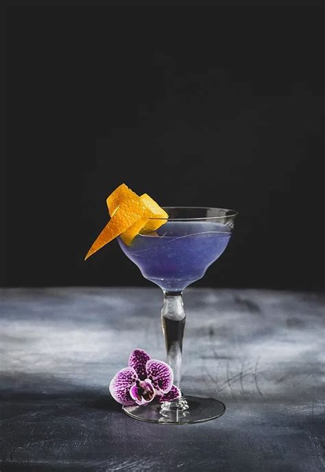 Water lily cocktail. Combine triple sec, crème de violette, lemon juice, and gin into a cocktail shaker filled with ice. Shake vigorously and strain into a coupe. Garnish with orange zest. 