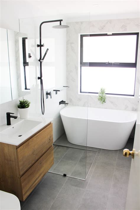 Wet room bath. This beautiful master bathroom features a spacious wet room and double vanity with lots of storage. Wood-look hexagon tiles with a linear drain were used for the shower floor. The white subway tile and soaker tub contrast beautifully against the deep textural grays of the floor, and the glass accent band around the space helps tie the whole ... 