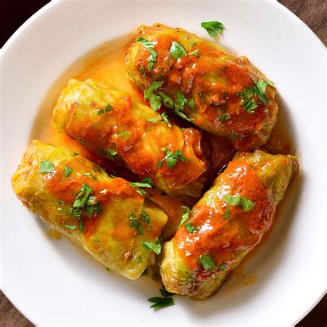 In a large bowl combine the tomato sauce, chicken broth, and remaining 1 teaspoon pepper. Stir the ingredients together, pour the mixture over the cabbage rolls and cover with a lid. Bake cabbage rolls for 90 minutes. Remove from the oven, let stand for 15 minutes and serve hot with sour cream and dill (optional).. 