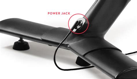 The power cord for a Peloton Bike plugs into a jack in the center of the Bike’s rear support leg. It can be difficult to see the hole when you are standing above the Bike, which is why lots of people have trouble locating it. When you plug it in, a green LED light will flash on.. 