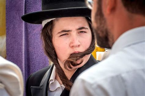 A young Hasidic Jewish lad curls his Peyot. · Hasidic Jewish family walking on the sidewalk in Brooklyn. · A middle aged orthodox Jewish man walks on Lee avenue ...
