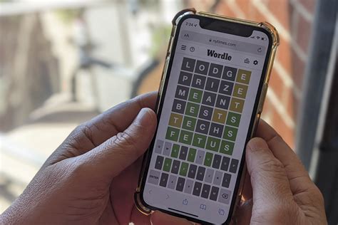 A person playing online word game "Wordle" on a mobile phone in Washington, DC on January 11, 2022. Newsweek has some hints and tips to help you crack Tuesday's puzzle.
