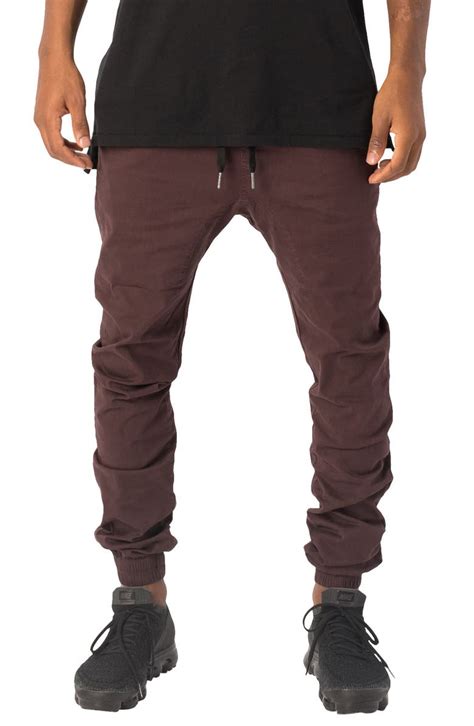 Zanerobe. The Zanerobe Men's Sureshot Jogger Pants are fabricated with high quality 98% cotton and 2% elastane. This fabrication creates a great fitting pant that is not only comfortable but extremely functional. Perfect for any occasion! Features a relaxed rise, elasticized waistband and cuff, as well as a drawstring closure, allowing these pants to ... 