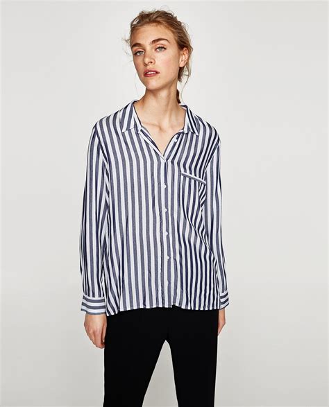 Johnny collar shirt made of a viscose blend. Cuffed sleeves falling below the elbow. Back pleat detail. Asymmetric hem with side vents. Button-up front.