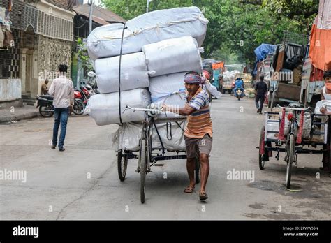 A Labourer Moving A Loaded Cart