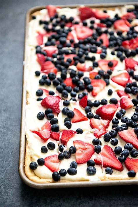an uncooked pizza with strawberries and blueberries on it is ready to