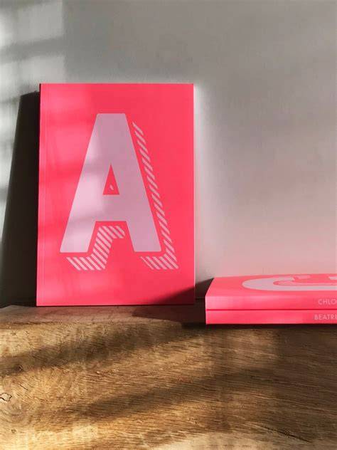 Pink lined notebook with initial T in a wreath
