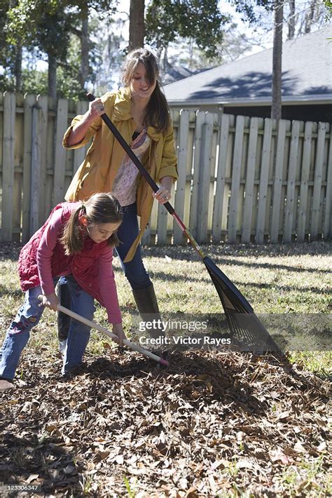 mother and daughter surrounded by leaves and twigs, sitting in a ...