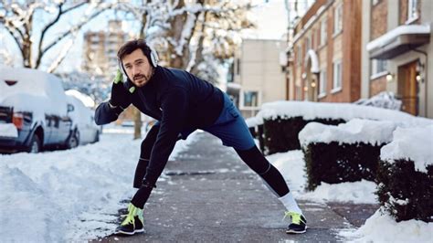 homme s'entrainant avec une barre de squat dans une salle de gym