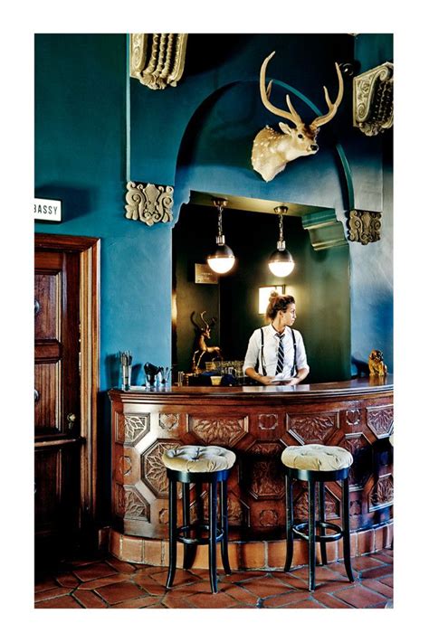 the bar has three stools in front of it and an antelope head on the wall