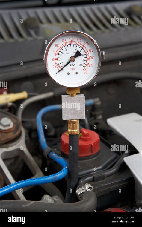 using a compression tester to measure the compression on a car engine